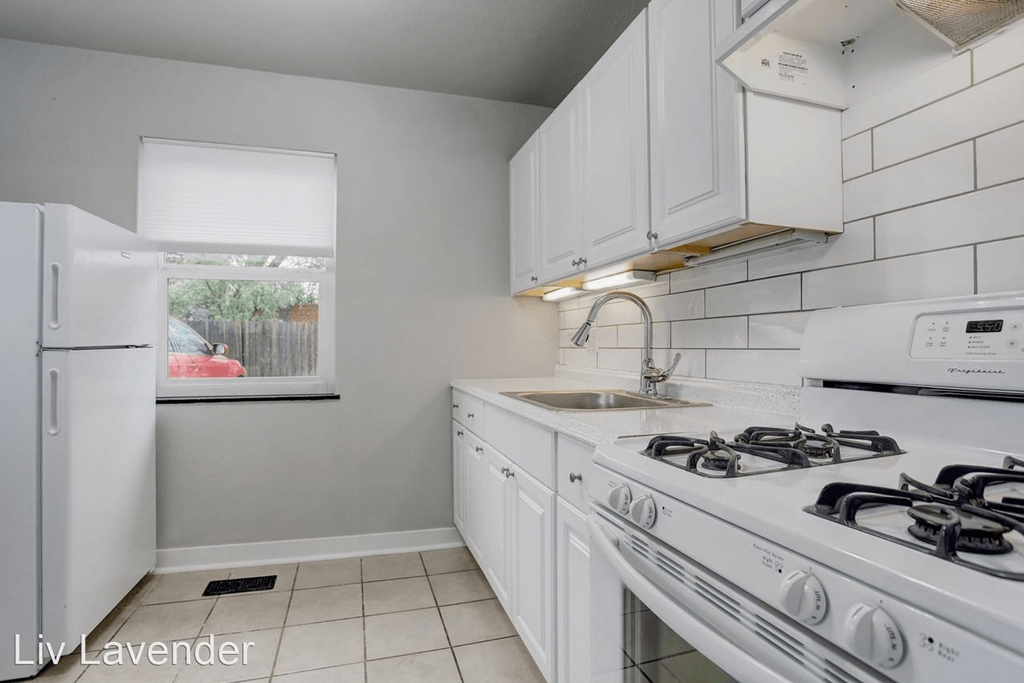 a white kitchen with white appliances and white cabinets
