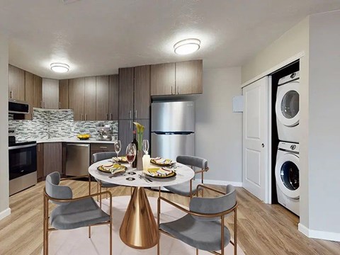A modern kitchen with a dining table set for two.