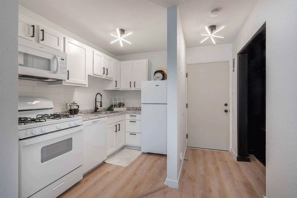 a white kitchen with white appliances and white cabinets