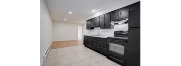 a kitchen with black cabinets and black appliances