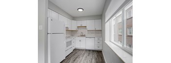 a kitchen with white cabinets and a white refrigerator
