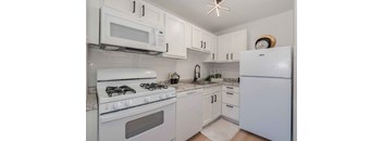 a white kitchen with white appliances and white cabinets