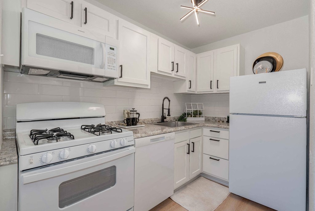 a white kitchen with white appliances and white cabinets