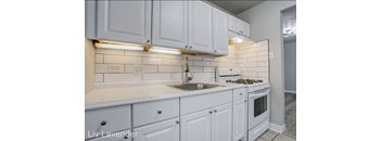 a white kitchen with white cabinets and a sink