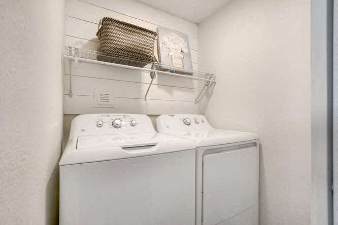 a white washer and dryer in a white room at The Iris Apartments, Colorado,80002