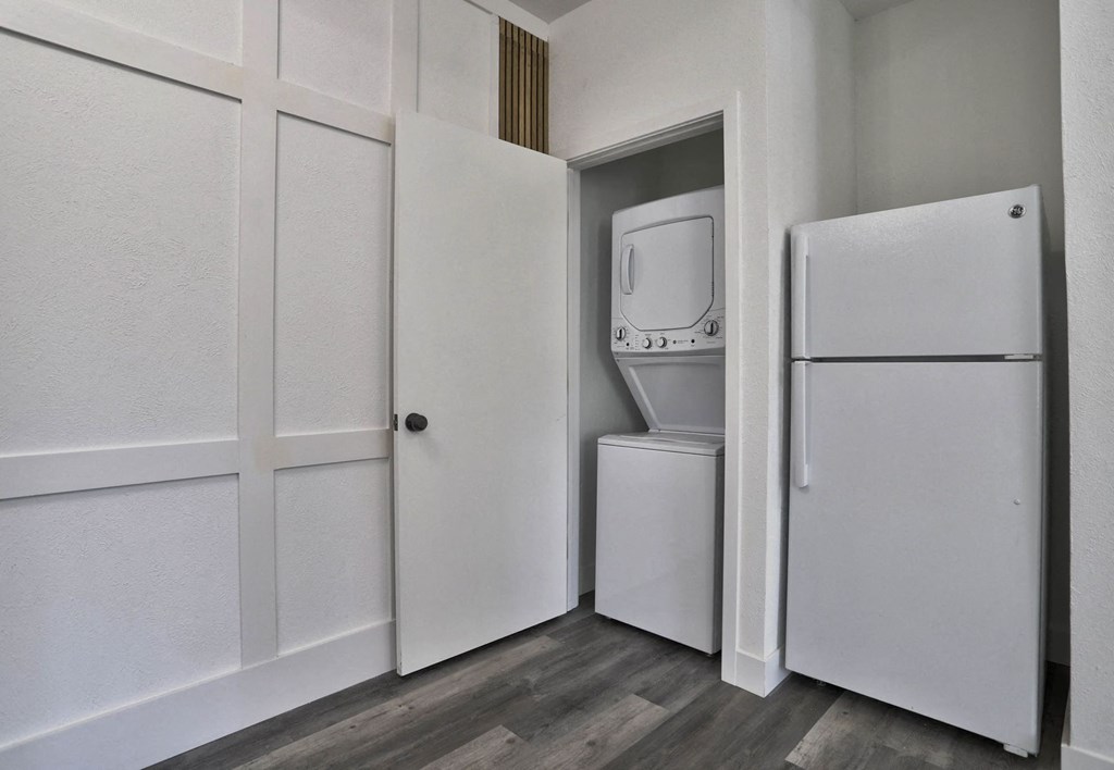 the closet in a small apartment with a refrigerator and a washing machine