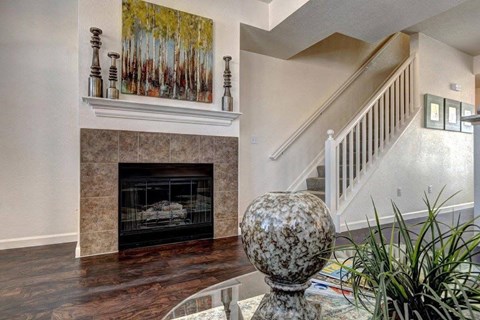 A living room with a fireplace and a painting above it.
