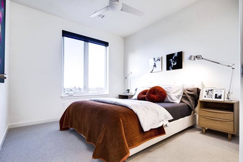 a bedroom with a bed and a ceiling fan