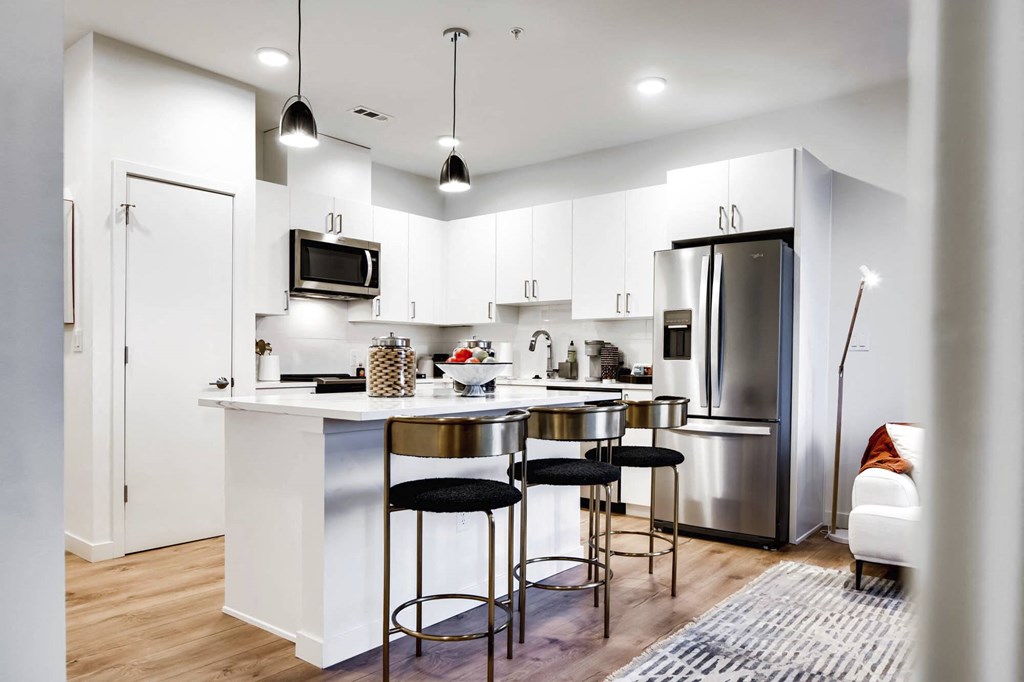 a kitchen with white cabinets and stainless steel appliances