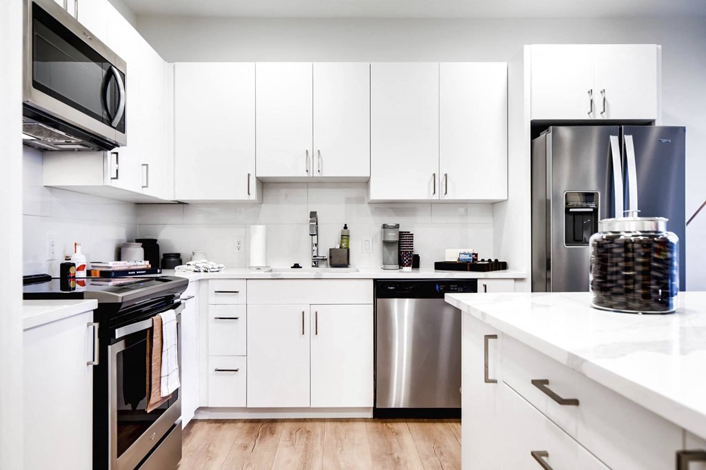a kitchen with white cabinets and stainless steel appliances