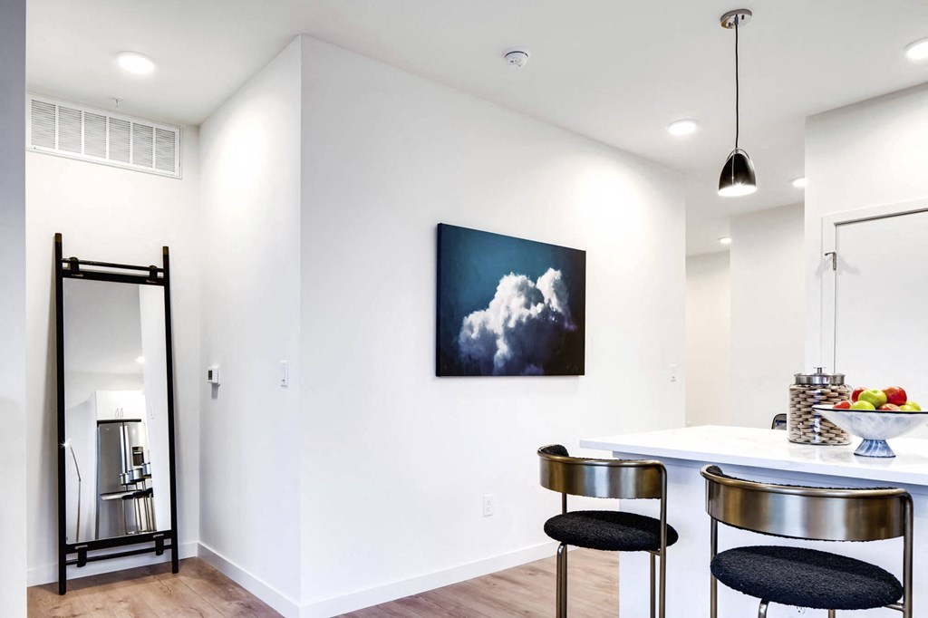 a kitchen with white walls and a white counter top with two black stools