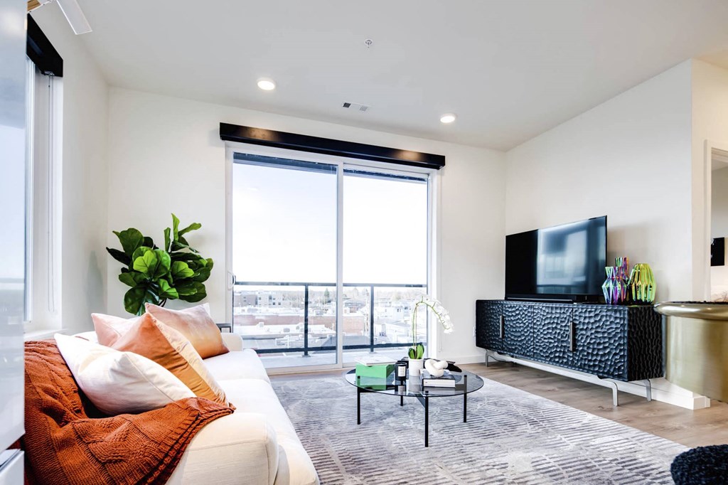 a living room with white walls and a large window