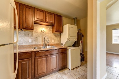 A kitchen with brown cabinets and a white refrigerator.