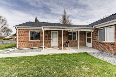 A brick house with a white door and windows.