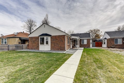 A house with a white door and a brick wall.