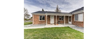 A brick house with a white door and windows.