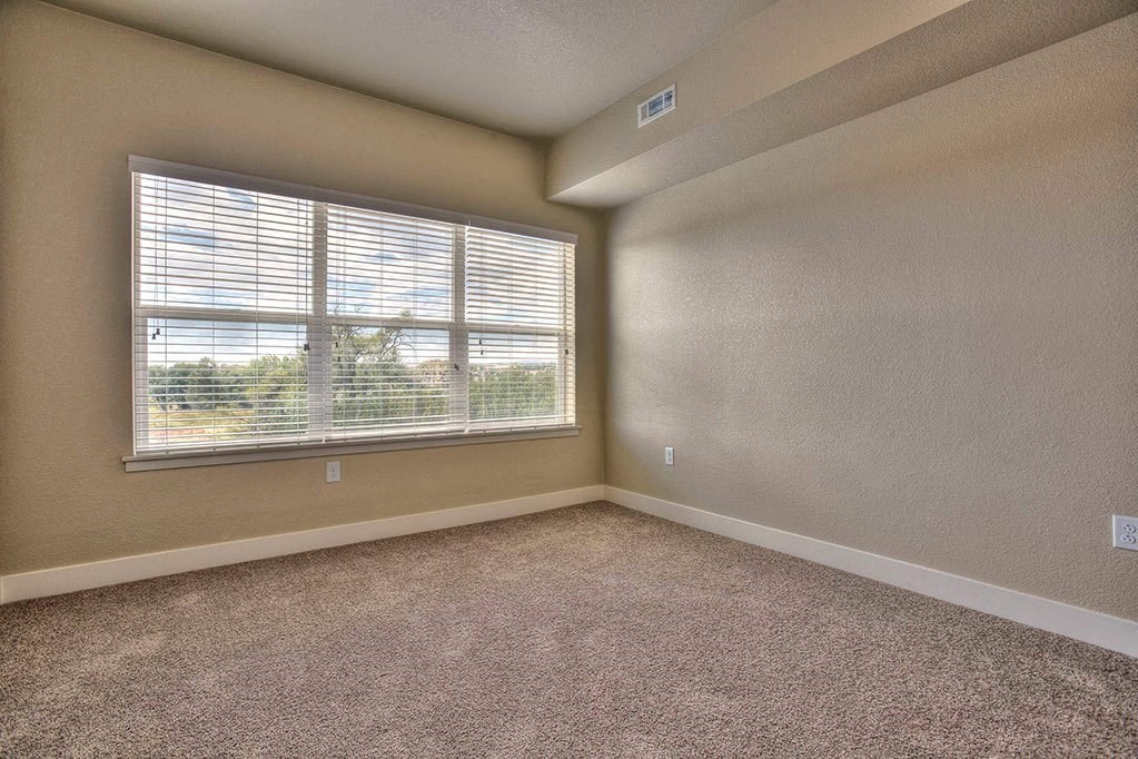 a bedroom with a large window and carpet