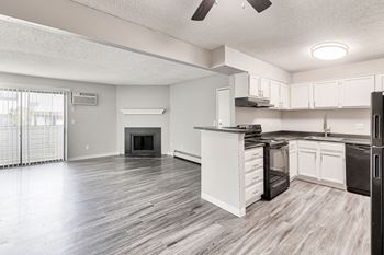 A modern kitchen with white cabinets and a black stove top oven.