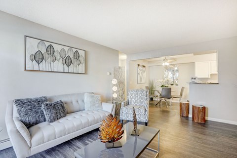 A living room with a white couch and a grey coffee table.