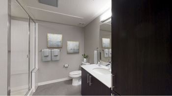 A bathroom with a toilet, sink, and mirror.