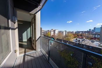A balcony with a glass door leading to a building.