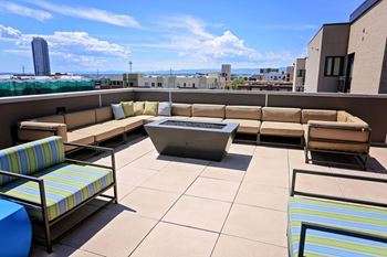 A patio with a table and chairs overlooking a cityscape.