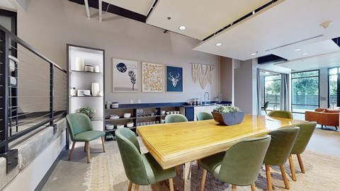 A dining room with a wooden table surrounded by green chairs.