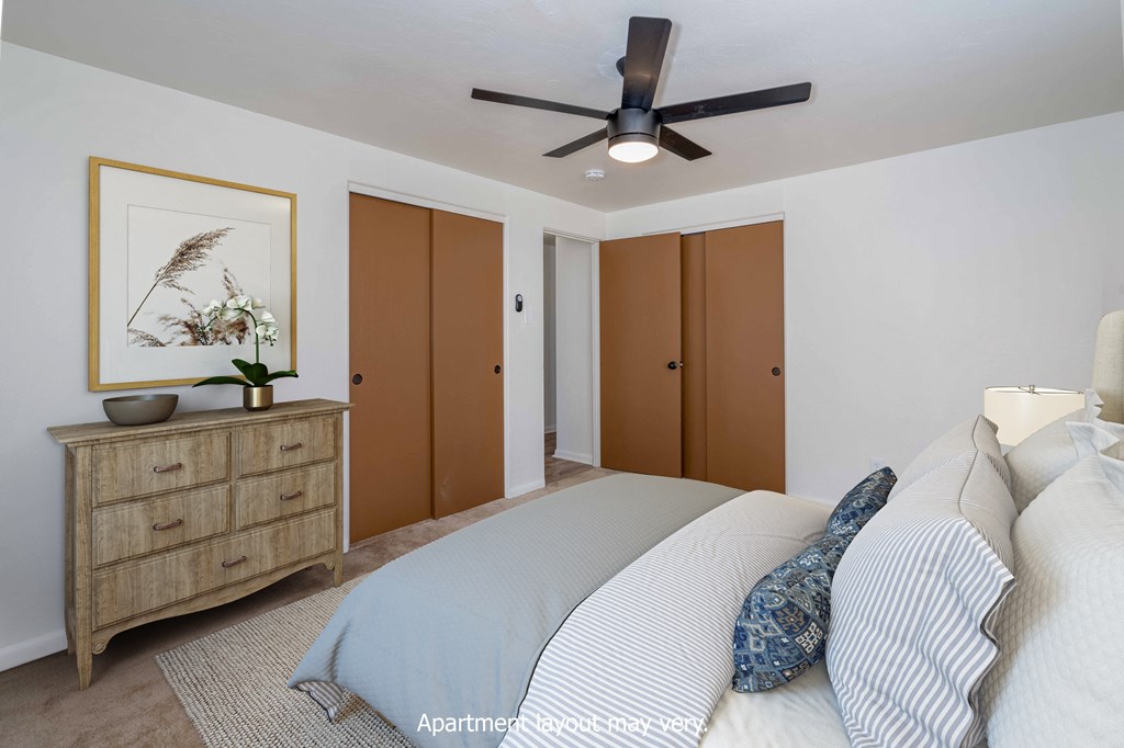 a bedroom with a bed and a ceiling fan