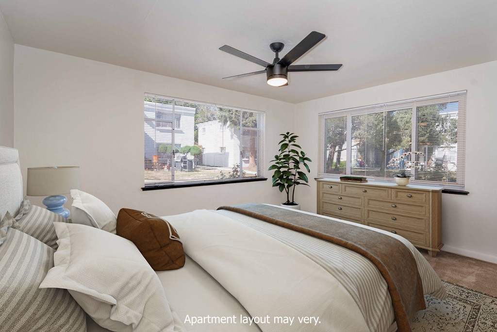 a bedroom with a large bed and a ceiling fan