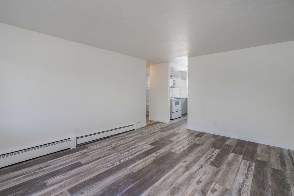 an empty living room with white walls and wood flooring