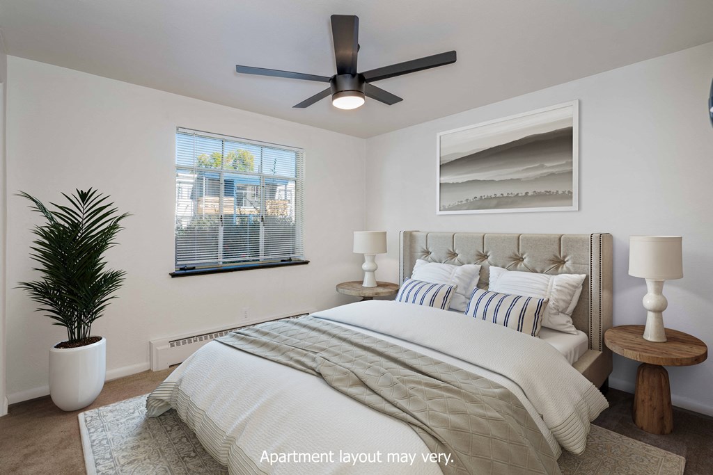 a bedroom with a large bed and a ceiling fan