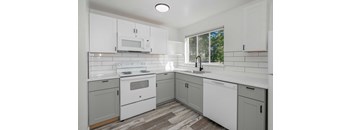 a white kitchen with white appliances and white cabinets