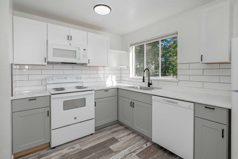 a white kitchen with white appliances and white cabinets