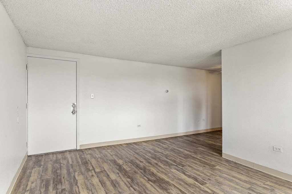 an empty living room with white walls and wood flooring