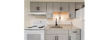 a kitchen with white appliances and granite counter tops and white cabinets