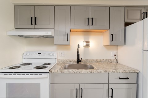 a kitchen with white appliances and granite counter tops and white cabinets