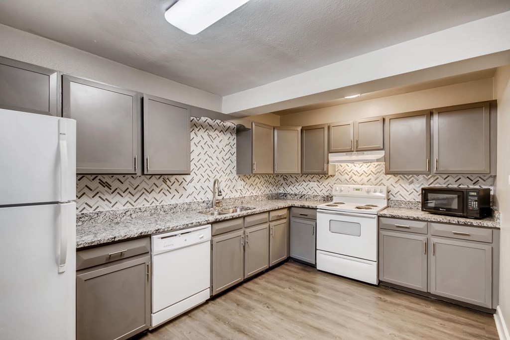 A kitchen with white appliances and brown cabinets.
