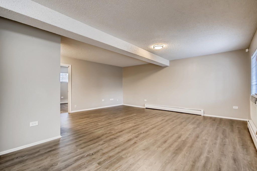 A room with wooden flooring and white walls.