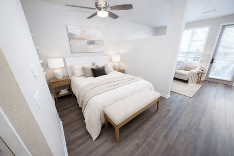 A bedroom with a large bed and a ceiling fan.