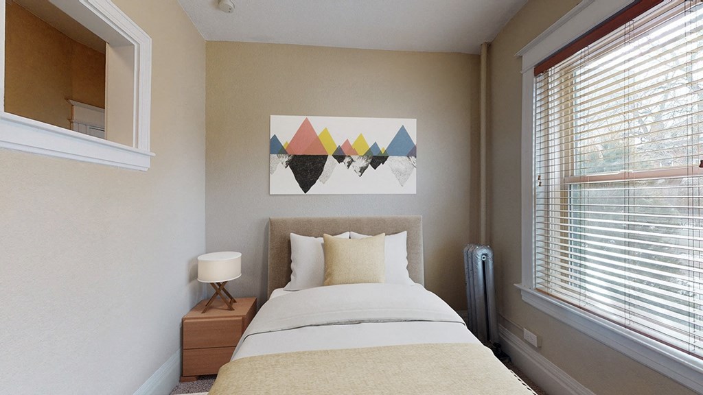 a small bedroom with a bed and a window