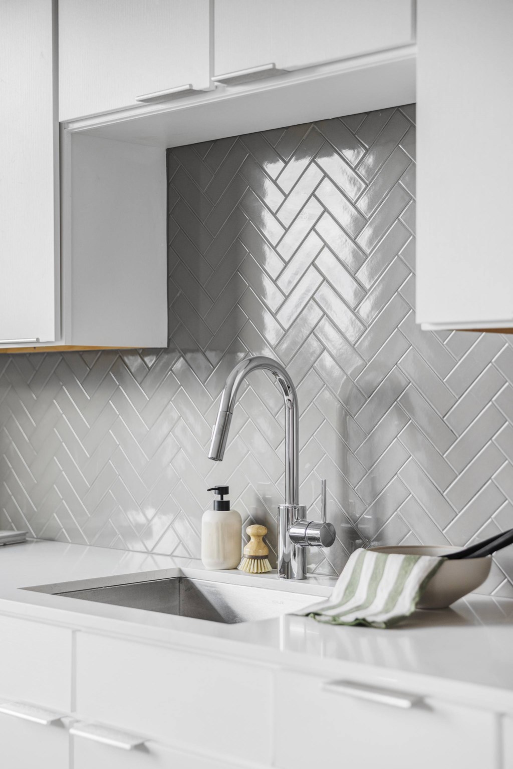 A white kitchen with a sink and a faucet.
