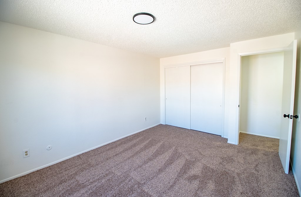 A room with a carpeted floor and white walls.