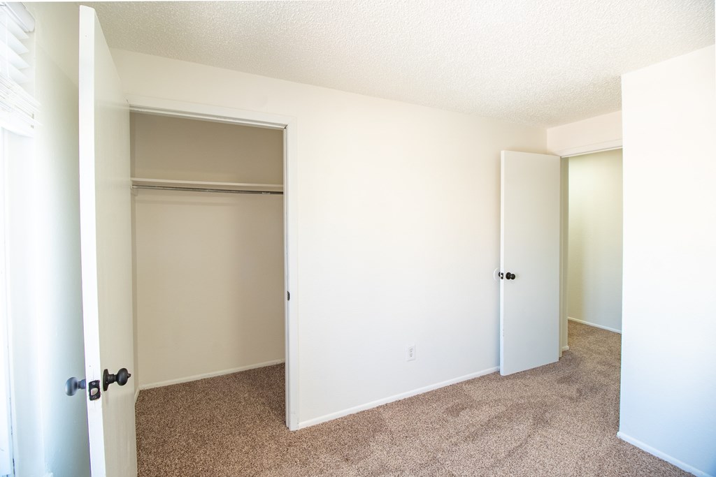 A white door is open to a room with carpeted floor.
