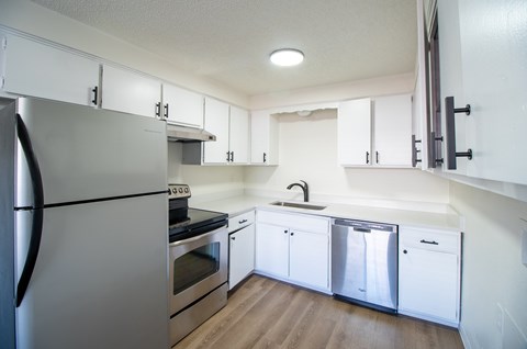 A kitchen with white cabinets and stainless steel appliances.