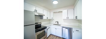 A white kitchen with a stove, oven, and dishwasher.
