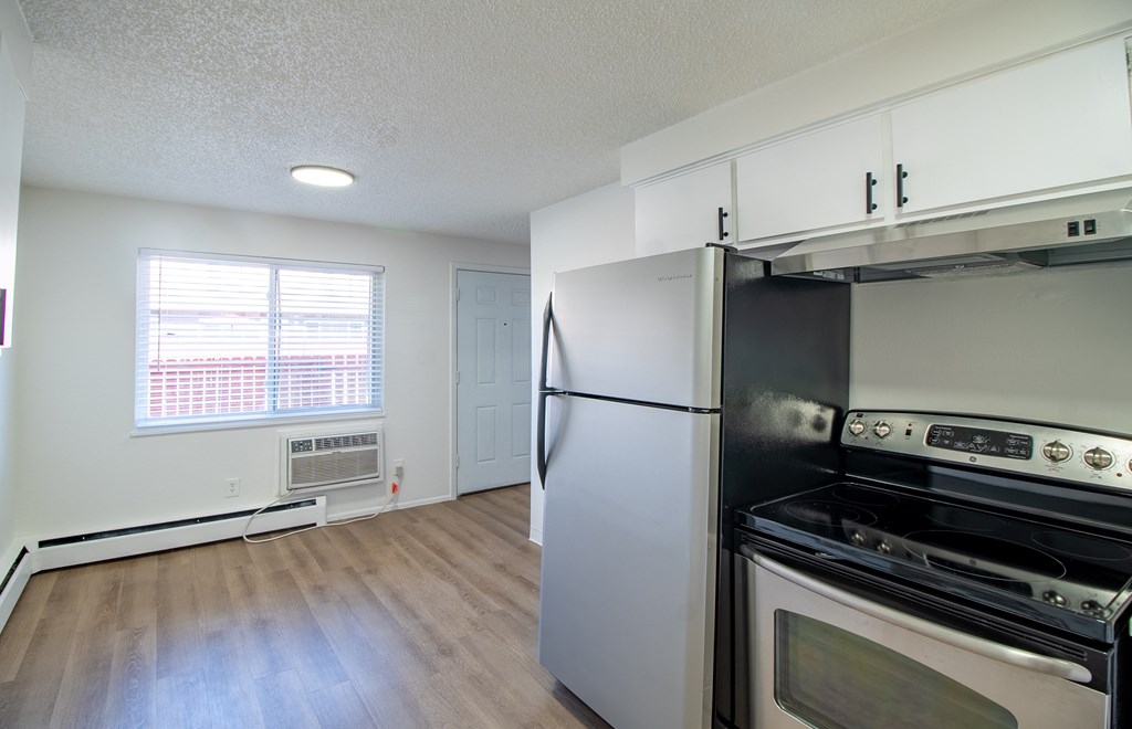 A kitchen with a white fridge and stove top oven.
