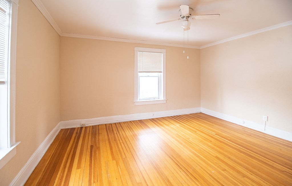 A room with wooden floors and a ceiling fan.