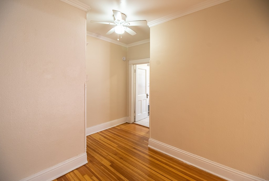 A room with a wooden floor and a ceiling fan.