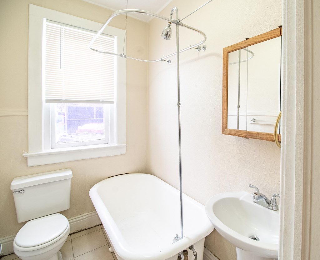A white bathroom with a toilet, sink, and bathtub.
