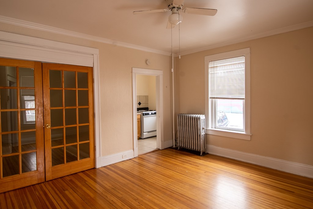 A room with a wood floor and a ceiling fan.